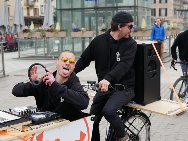 Deux membres de l'association portant le sweat officiel de Resaca Production lors d'une groovy bike, une déambulation à vélo dans les rues de Chambéry, accompagnée d'une ambiance house et techno diffusé sur notre système son autonome.